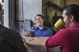 Workers enjoying coffee break in warehouse