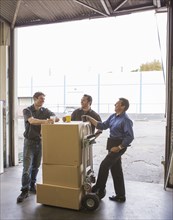 Workers enjoying coffee break at warehouse loading dock