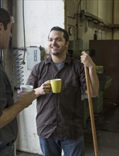 Workers having coffee together in warehouse