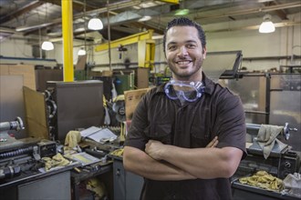 Hispanic worker smiling in repair shop