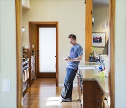 Man using cell phone in kitchen