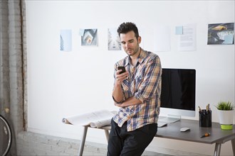 Caucasian architect using cell phone in office