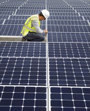 Asian technician working on solar panels