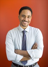 Black businessman smiling with arms crossed