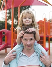 Caucasian father holding daughter at playground