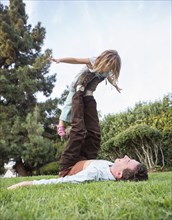 Caucasian father and daughter playing in grass