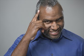 Older African American man tapping his forehead