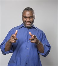 Smiling older African American man pointing
