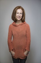 Caucasian woman smiling with hands in pockets