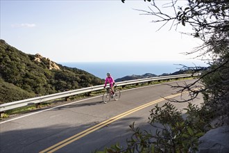 Caucasian woman biking on remote mountain road