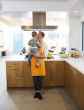 Caucasian father kissing daughter in kitchen