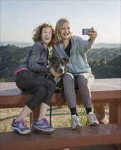 Caucasian women taking selfie on hilltop