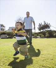 Hispanic father and son playing in park