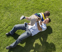 High angle view of Hispanic father and son playing on lawn