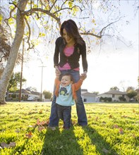 Hispanic mother playing with son in park