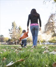 Hispanic mother walking with son in park