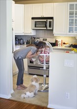 Mixed race mother kissing baby in kitchen