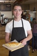 Server carrying calzone in cafe