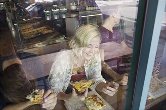Caucasian woman eating pizza in cafe