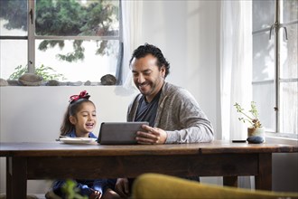 Hispanic father and daughter using digital tablet
