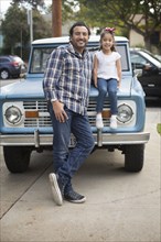 Hispanic father and daughter near truck