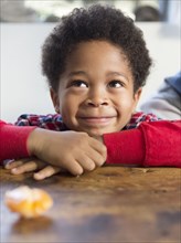 Mixed race boy smiling at table