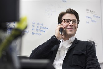 Caucasian businessman talking on cell phone in office