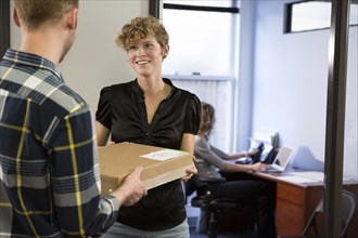 Caucasian businessman delivering packages in office