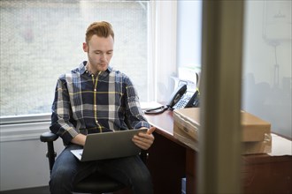 Caucasian businessman using laptop in office