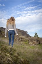 Girl walking on grassy hillside