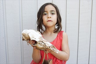 Close up of girl holding animal skull