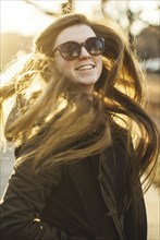 Smiling Caucasian woman tossing her hair outdoors