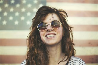 Caucasian woman wearing sunglasses at American flag