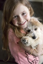 Close up of Caucasian girl hugging puppy
