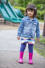 Girl wearing rain boots at playground