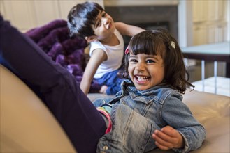Smiling girl playing on sofa in living room