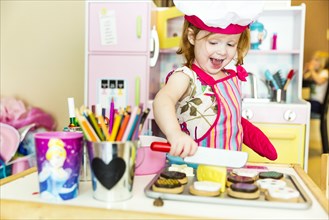 Caucasian girl playing with toy kitchen