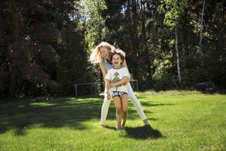 Mother playing with son in backyard