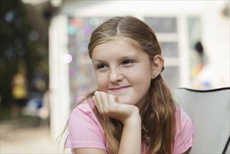 Caucasian girl resting chin in hand