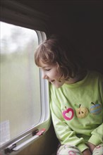 Caucasian girl looking out train window