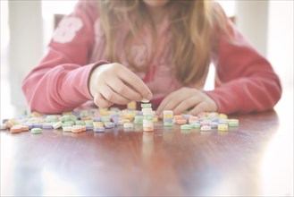 Caucasian girl stacking candy on table