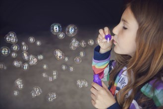 Caucasian girl blowing bubbles