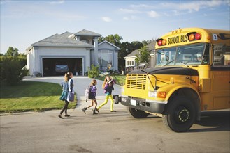 Caucasian girls walking to school bus