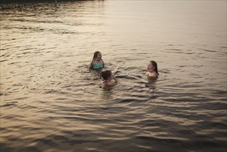 Caucasian girls swimming in lake
