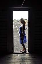Woman standing in doorway of train in train yard