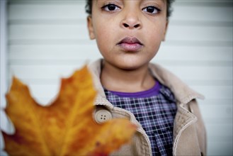 Close up of girl holding autumn leaf