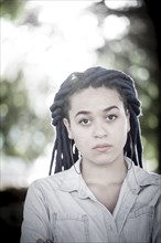 Serious woman with dreadlocks outdoors