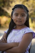 Hispanic girl standing with arms crossed