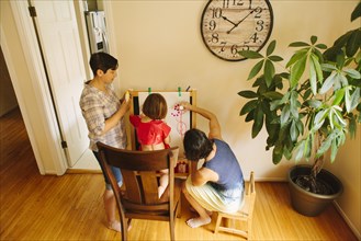 Caucasian family drawing on easel