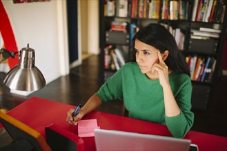 Hispanic woman working at home office